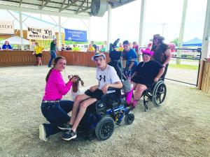 Sr. Goat Show Woman Riley Bussell assists Sunshine Day participant Trent Shannon